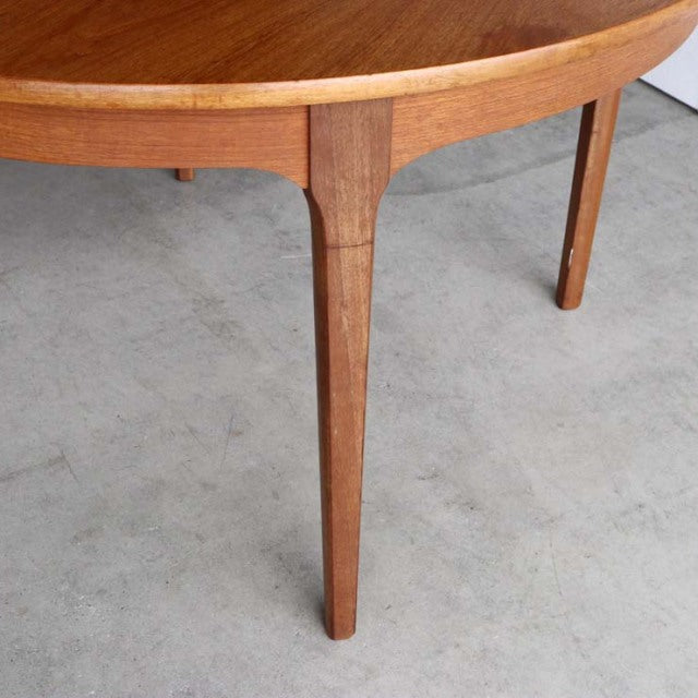 Mid-century British vintage teak dining table leg with smooth wood grain and rounded oval edge.