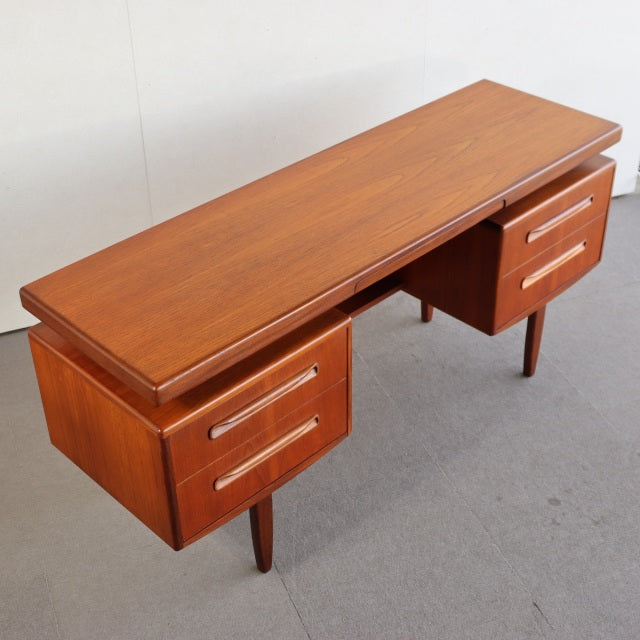 Mid-century British vintage teak desk by G-PLAN with clean wood grain, tapered legs, and two drawer units.