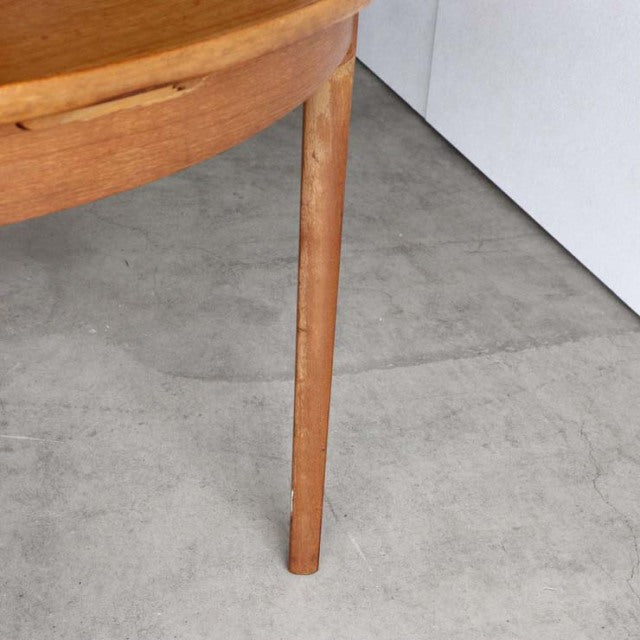 Mid-century British vintage teak dining table leg with warm wood grain and slender tapered form.
