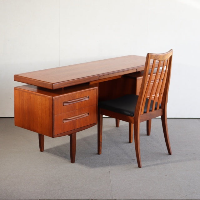 Vintage teak G-Plan British mid-century desk with smooth wood grain, two drawers, and tapered legs, paired with matching.