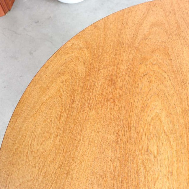 Close-up of vintage teak dining table top showing smooth grain and warm honey tone, mid-century British design.