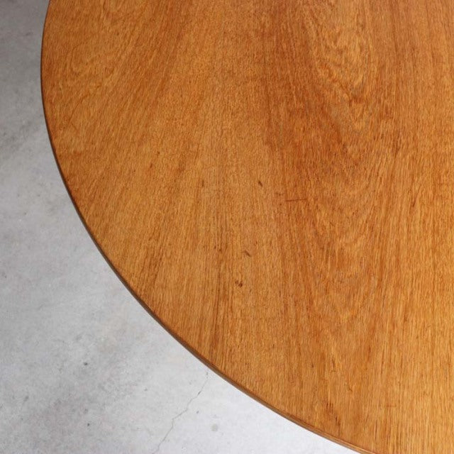 Round teak dining table top with warm wood grain, mid-century British vintage style.
