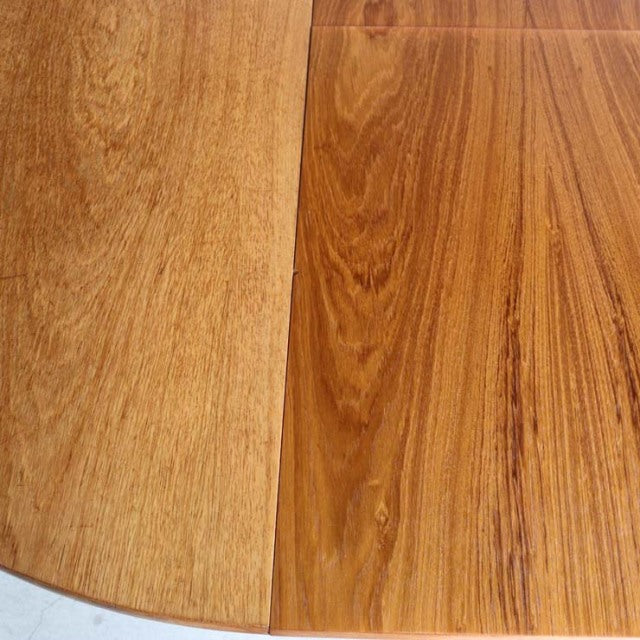 Close-up of vintage British teak dining table top showing rich wood grain and smooth mid-century finish.