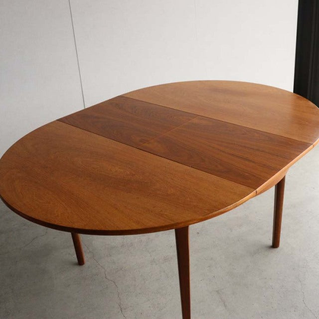 Vintage mid-century British teak dining table by Nathan with oval top and tapered legs.