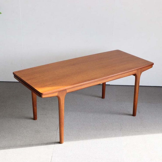 Vintage British mid-century teak coffee table by McIntosh with smooth wood grain and tapered legs.
