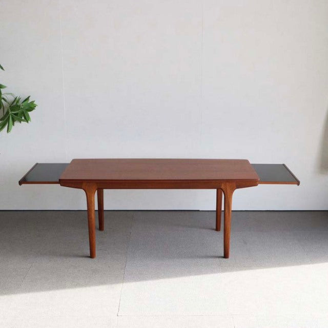 Mid-century British McIntosh teak coffee table with extendable dark wood side panels and slender tapered legs in pristine.