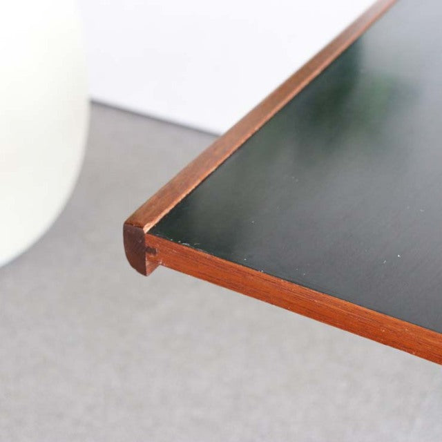 Mid-century British McIntosh teak coffee table corner with black laminate top and rounded edges.
