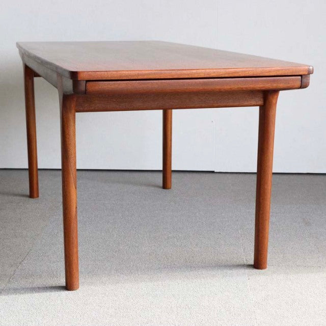 Vintage British McIntosh mid-century teak coffee table with smooth wood grain and slender round legs.