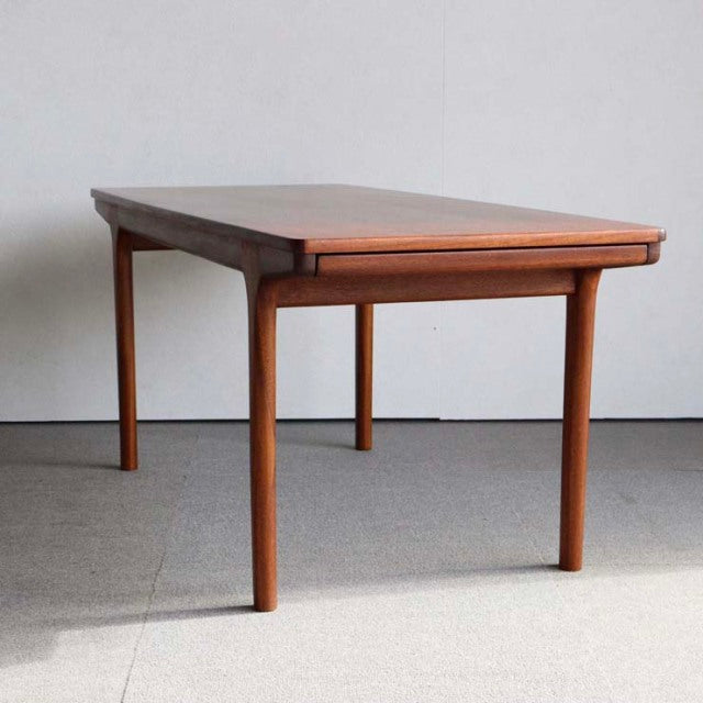 Vintage McIntosh mid-century teak coffee table with rich wood grain and slender round legs.