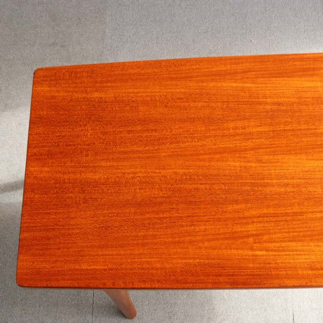 Vintage McIntosh mid-century teak coffee table with smooth wood grain and slender round legs.