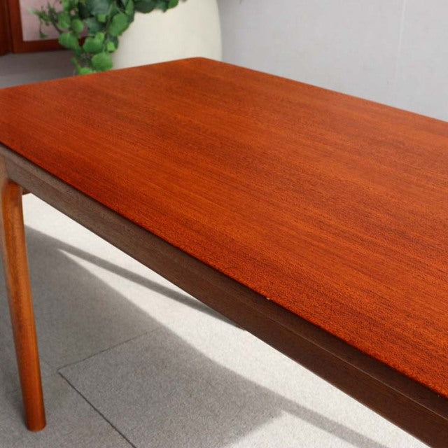 Mid-century British McIntosh teak coffee table with rich wood grain and slender tapered legs.
