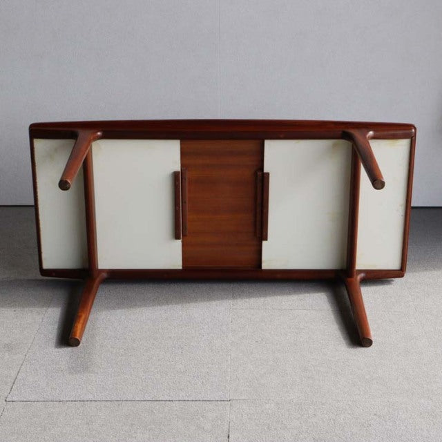 Vintage British mid-century McIntosh teak coffee table with smooth wood grain and angled legs, showcasing solid.