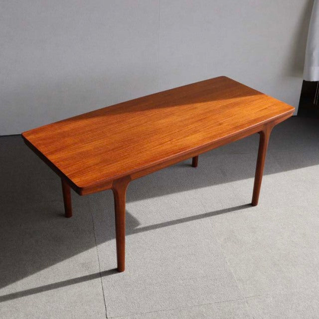 Mid-century British McIntosh coffee table in vintage teak with smooth wood grain and tapered round legs.