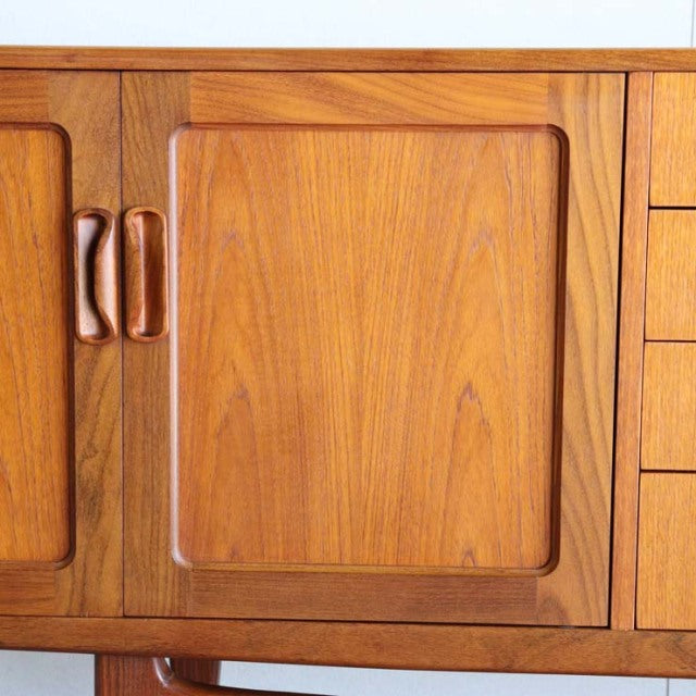 Vintage British mid-century teak sideboard by G-PLAN with smooth wood grain and curved wooden handles.