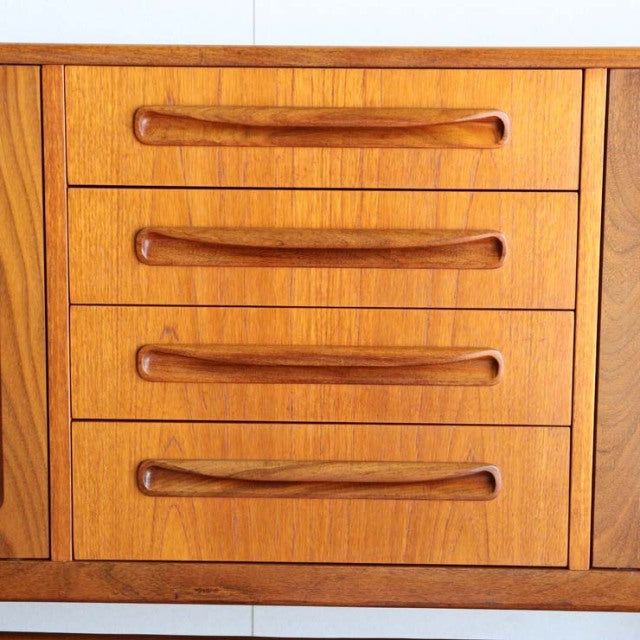 Mid-century British vintage teak sideboard drawer section with smooth wood grain and curved integrated handles.