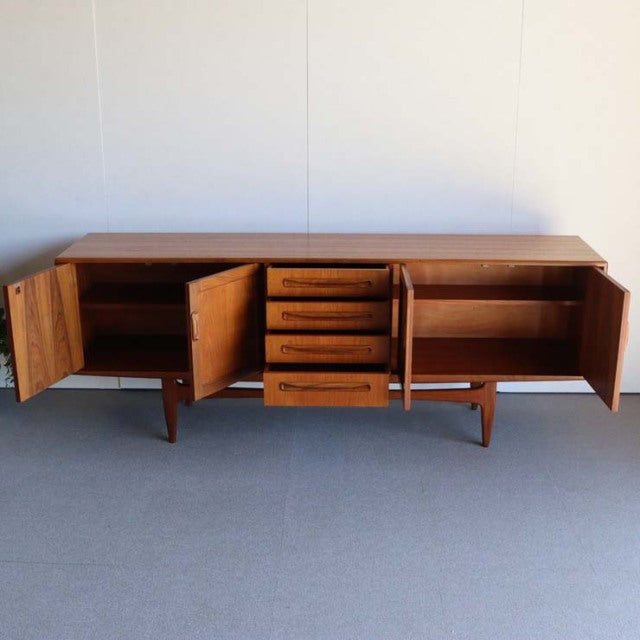 Vintage British mid-century teak sideboard by G-PLAN with rich wood grain, tapered legs, and multiple drawers and cabinets.