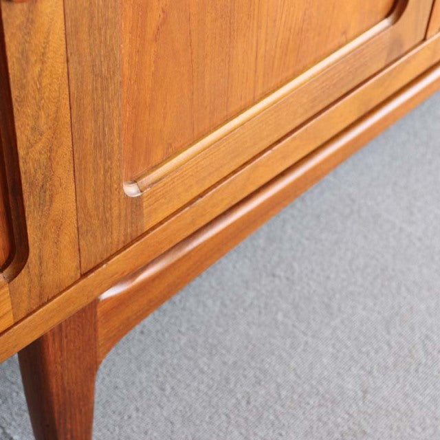 British mid-century G-Plan Fresco teak sideboard corner with smooth wood grain and tapered legs.