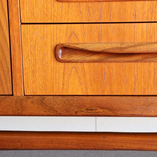 Mid-century British vintage teak sideboard drawer with smooth wood grain and curved handle detail.