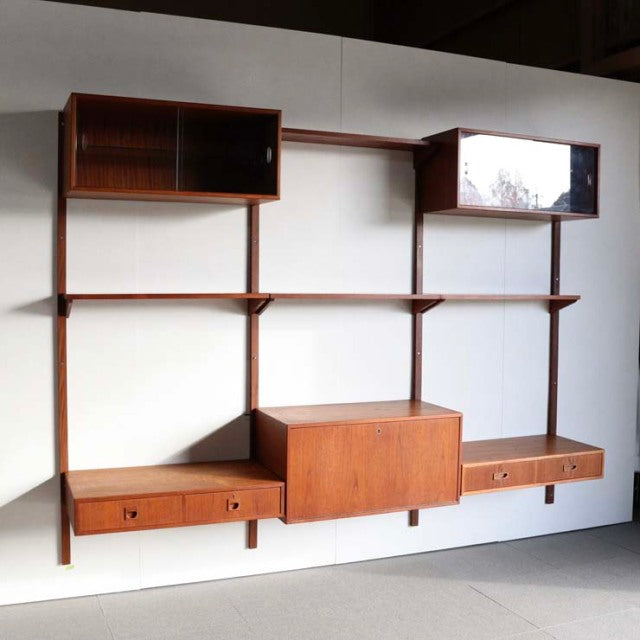 Mid-century Danish teak wall-mounted cabinet system by PS System, featuring symmetrical open shelves, two closed storage.