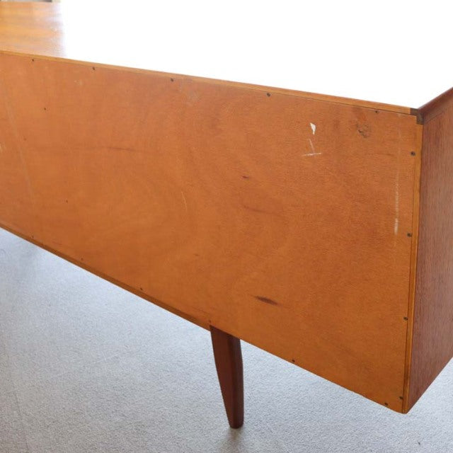 Vintage teak G-Plan sideboard drawer corner showing smooth grain and tapered mid-century British legs.