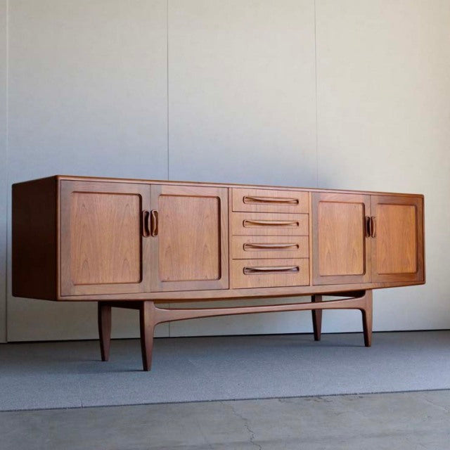 Mid-century British G-Plan Fresco sideboard in teak with rich wood grain, tapered legs, four doors, and five central drawers.