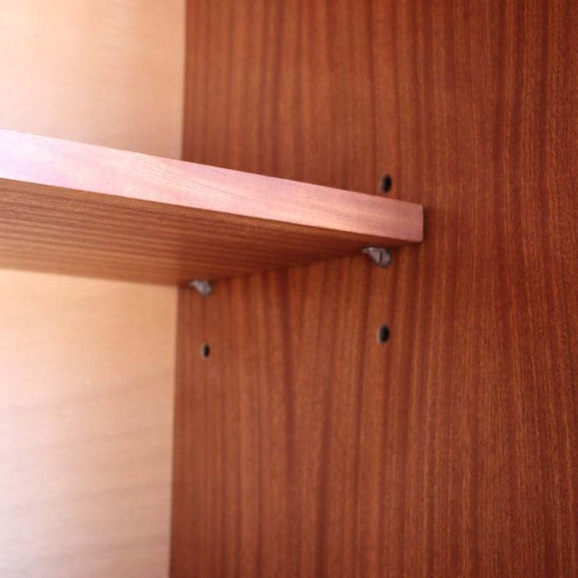 Close-up of vintage teak sideboard interior showcasing wood grain and mid-century British craftsmanship details.