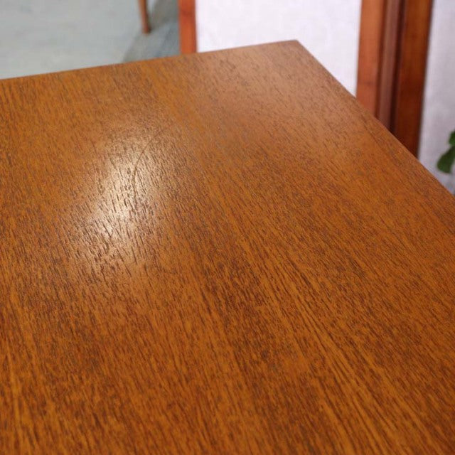 Close-up of teak wood grain on vintage British G-Plan mid-century sideboard top, showing warm honey tones.