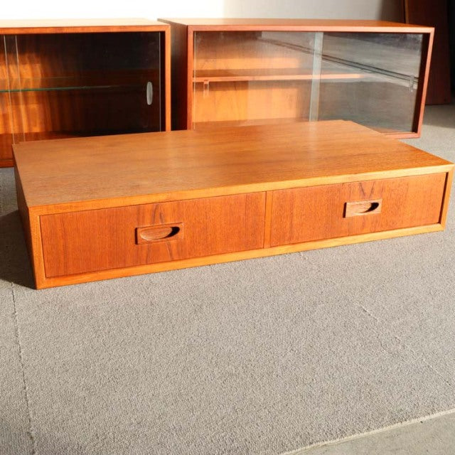 Vintage teak mid-century low cabinet with smooth grain, rounded edges, and recessed handle drawers.