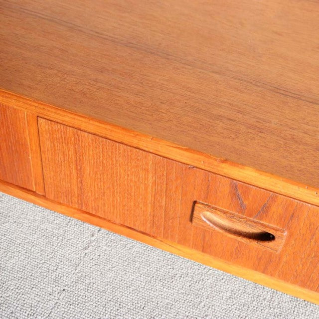 Vintage mid-century Danish teak cabinet drawer with rich wood grain and sculpted recessed handle detail.