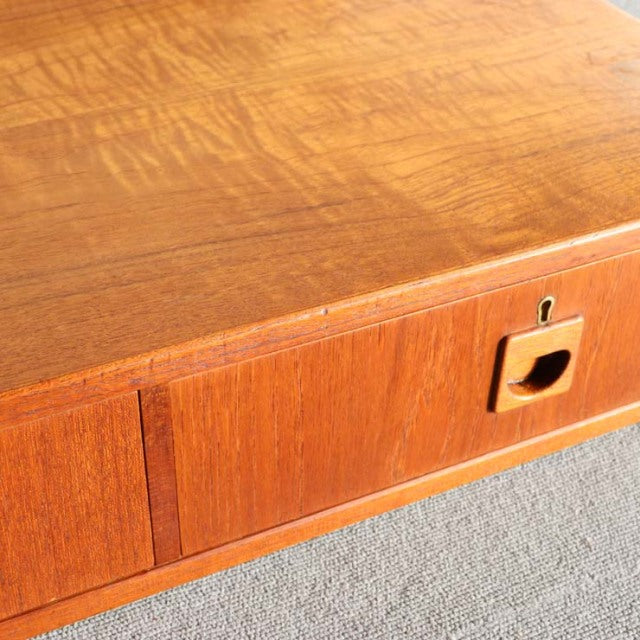 Mid-century vintage teak cabinet drawer front with visible wood grain and Danish design detail.