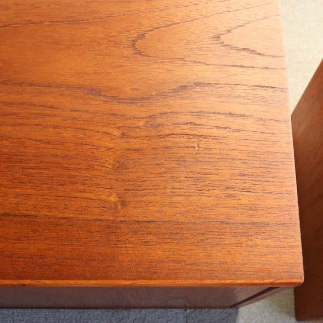 Close-up of vintage Danish teak cabinet corner showing smooth wood grain and mid-century craftsmanship.