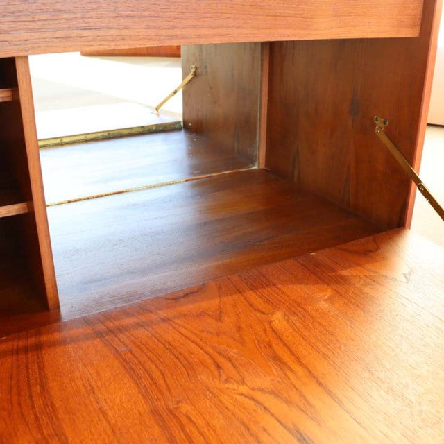 Mid-century vintage teak cabinet interior with rich wood grain and brass hinges from Danish PS system design.