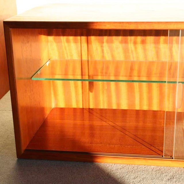 Mid-century vintage Danish teak cabinet with glass shelf and clear sliding doors, fine wood grain visible.
