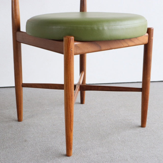 Vintage British mid-century teak dining chair with round olive green vinyl seat and tapered legs.