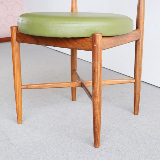 Vintage British mid-century teak dining chair with round green vinyl seat and tapered legs.