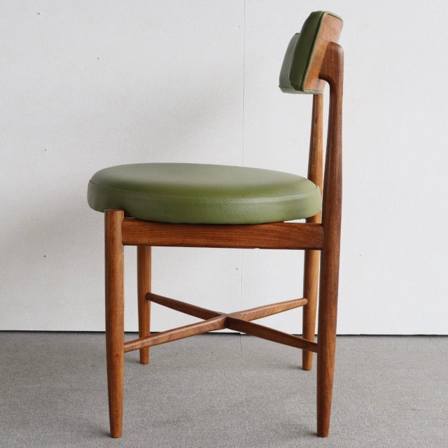 Vintage British mid-century teak dining chair with round olive green upholstered seat and slim tapered legs with.