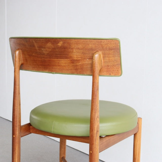 Vintage British mid-century teak dining chair with curved backrest and round olive green vinyl seat, sleek tapered legs.
