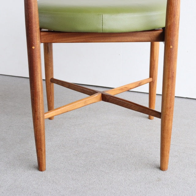 Mid-century British teak dining chair leg detail with green vinyl seat and crossed wooden stretcher, vintage style from.