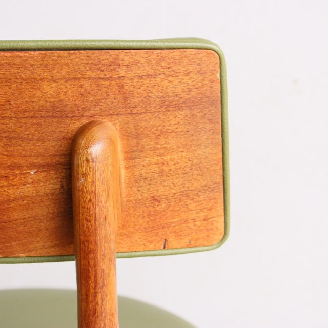 Vintage teak dining chair backrest with smooth wood grain and rounded vertical support, mid-century British design.