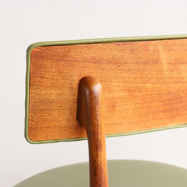 Close-up of vintage teak British mid-century dining chair backrest with visible wood grain and natural finish.