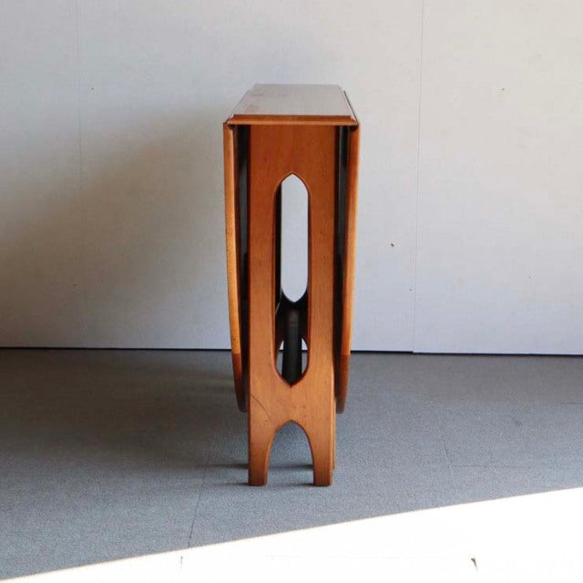 Vintage teak drop-leaf table by JENTIQUE with slender British mid-century legs and smooth wood grain.