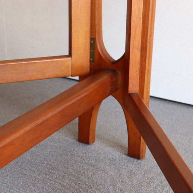 Close-up of vintage British mid-century teak drop-leaf table leg with smooth grain and rounded edge design from JENTIQUE.