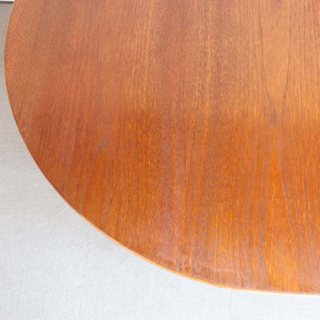 Round vintage teak drop-leaf table top with smooth wood grain, mid-century British design.