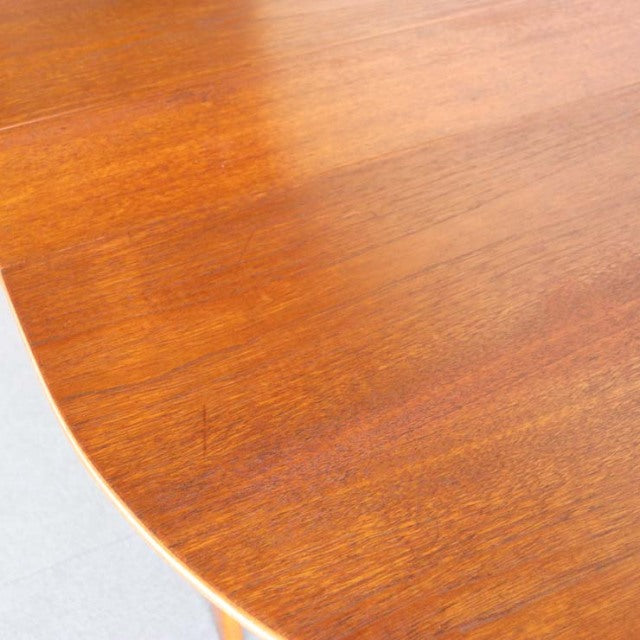 Mid-century British vintage teak drop-leaf table with rich wood grain and smooth rounded edge.