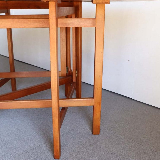 Vintage teak drop-leaf table leg detail showcasing mid-century British craftsmanship with smooth wood grain and sturdy.