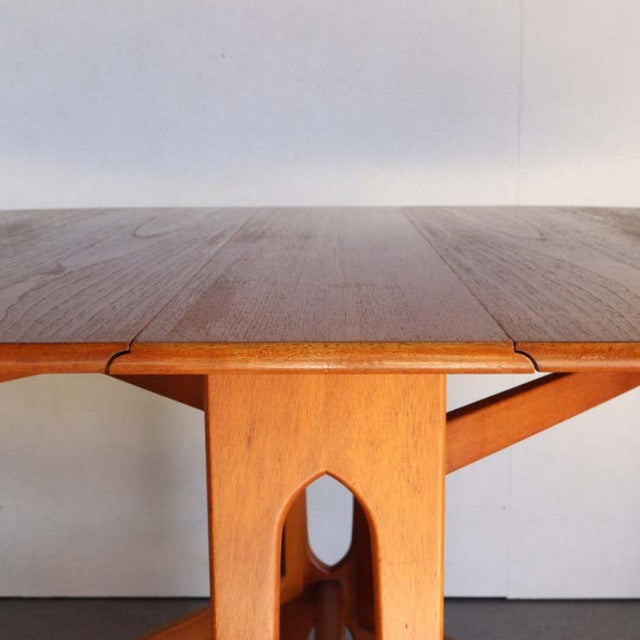Vintage teak JENTIQUE mid-century British drop-leaf table with smooth wood grain and sculpted legs.