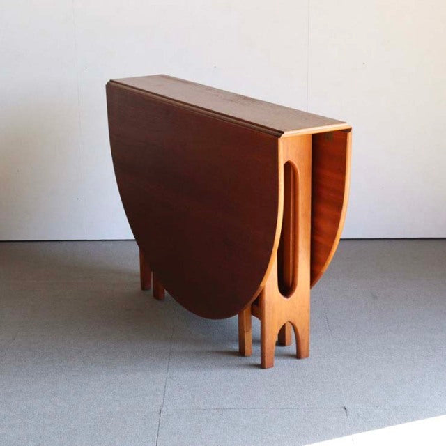 Vintage teak drop-leaf dining table by British brand Jentique, mid-century Denmark style, smooth wood grain, sculpted legs,.