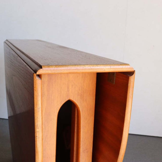 Mid-century British vintage teak drop-leaf table by JENTIQUE with arched cutout and smooth grain finish.