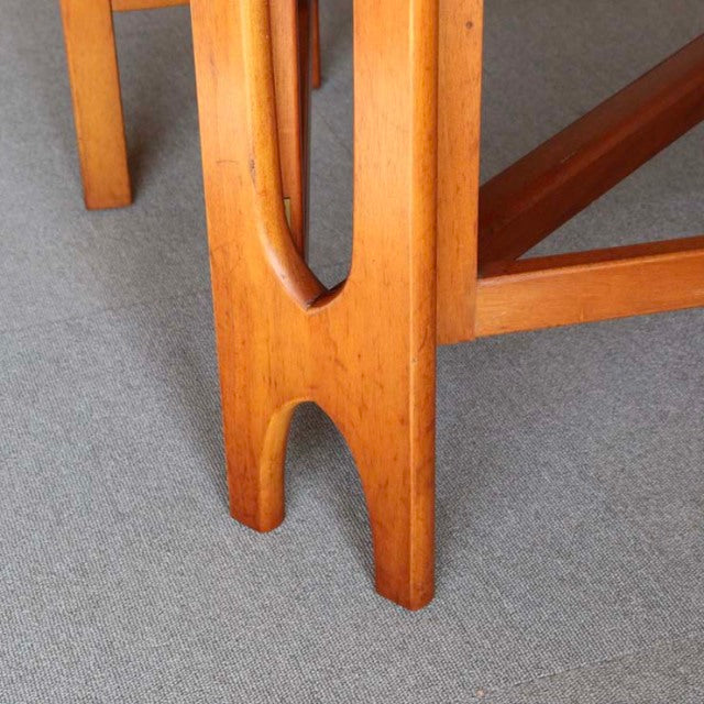 Close-up of vintage teak drop-leaf table leg with mid-century British-Danish design, showcasing warm wood grain and elegant.