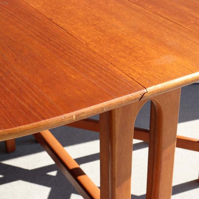 Mid-century vintage teak drop-leaf table by British brand JENTIQUE with smooth wood grain and rounded edges.